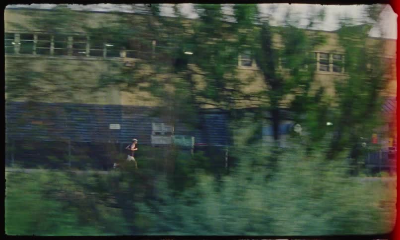A lone runner makes their way past a large warehouse