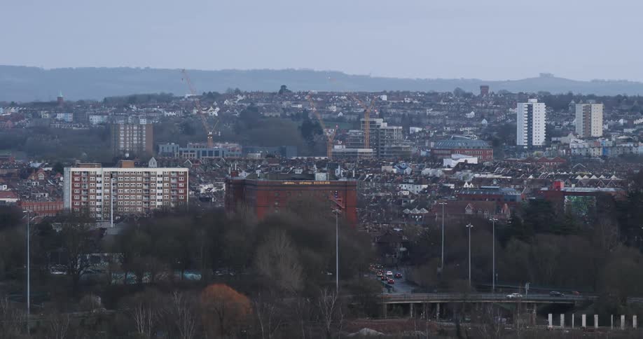 A panoramic view of a cityscape during twilight with multiple buildings of varying heights