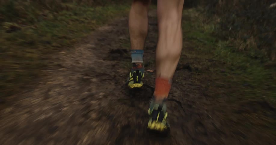 Legs of a person running on a dirt path