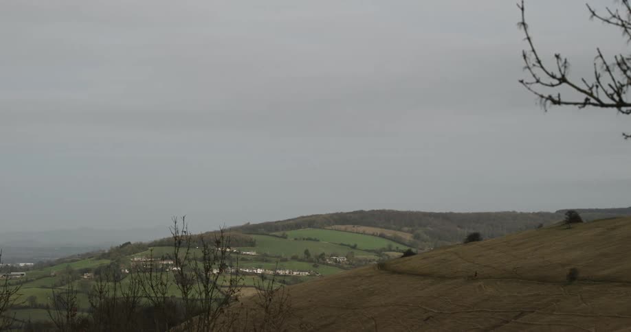 Rural landscape with gentle hills areas of vegetation and a cloudy sky