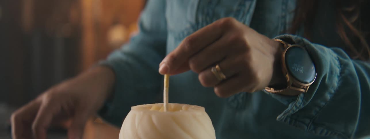Close up of a person securing the wick of a homemade candle