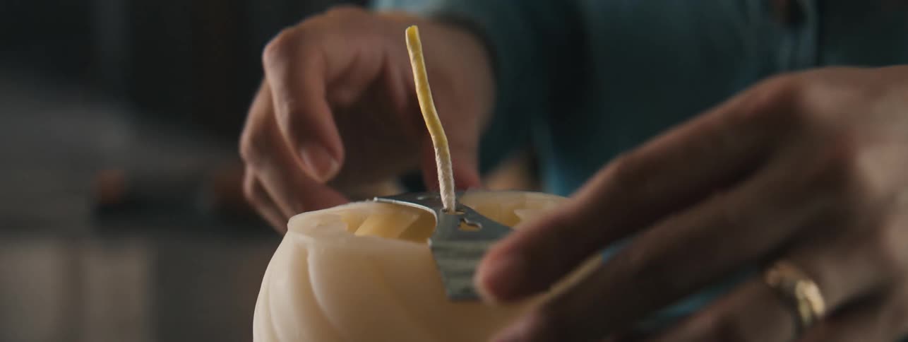 Hands of a craftswoman working on an object by placing a thread