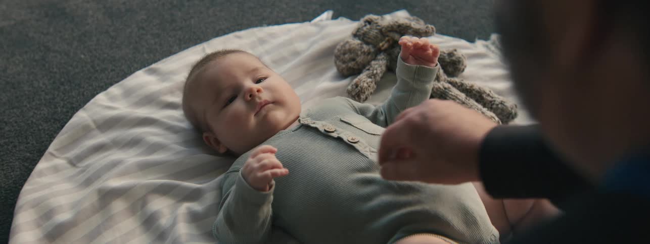 Father briefly stops his baby from crying by stroking the kids belly