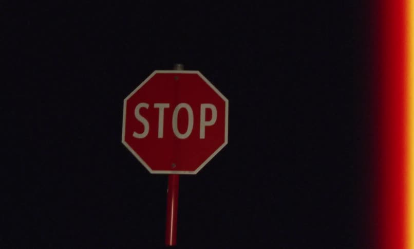 A stop sign is in the night sky