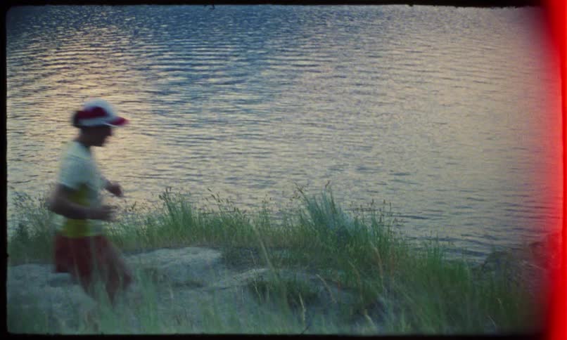 A woman jogging near a lake captured on vintage film