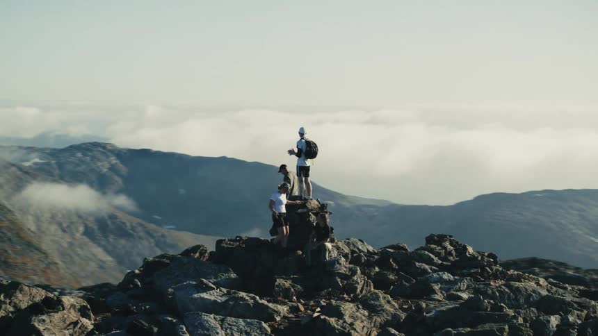 A group of people climb on rocks at the peak