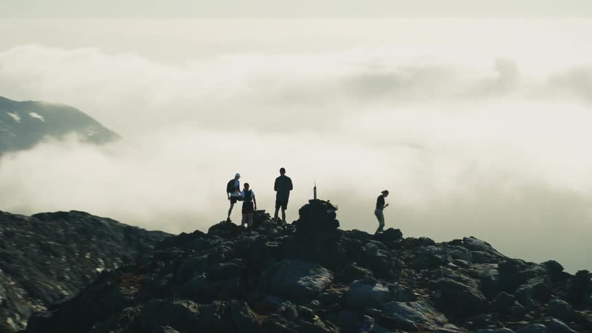 A group of people hike on the peak of a mountain