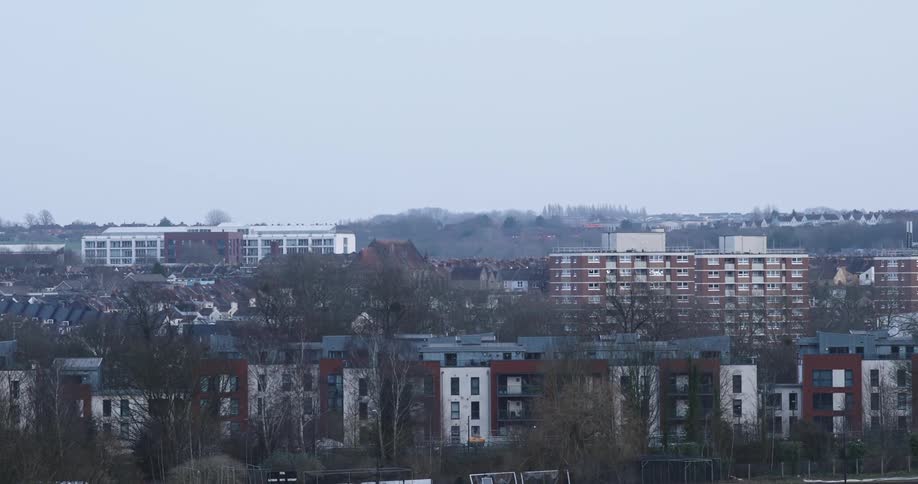 Apartment buildings border a park in a residential neighborhood on a hazy day