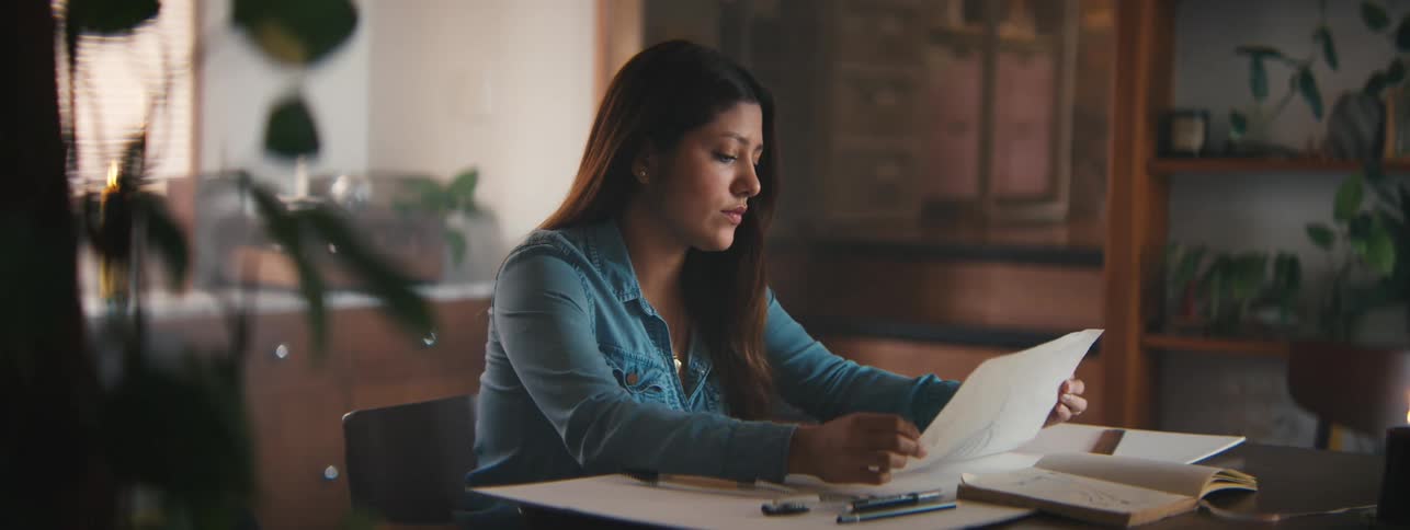 Woman sitting at a table and looking at a project