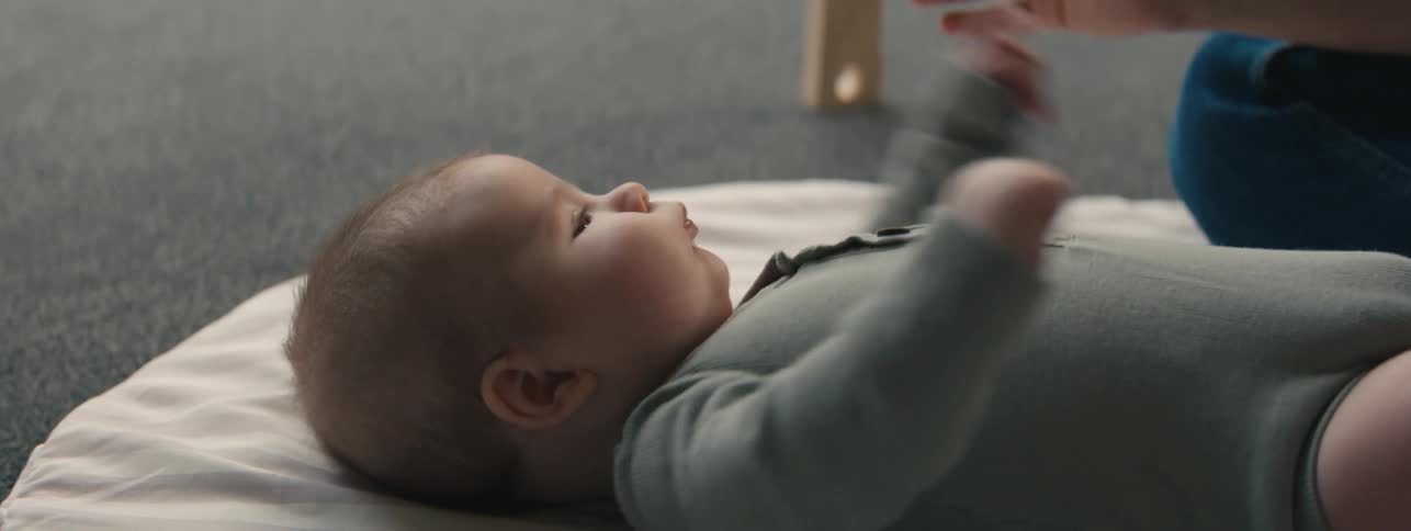 Baby lying on a white blanket on the floor