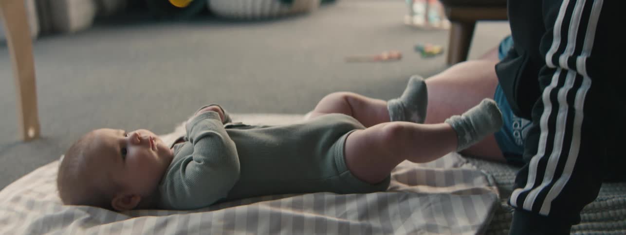Father sitting holding a toy and interacting with his baby