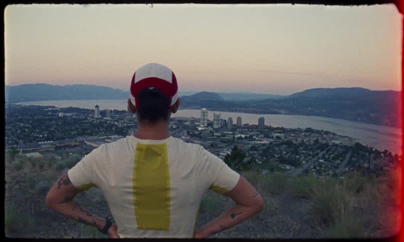 A man looks at the city from the top of a mountain
