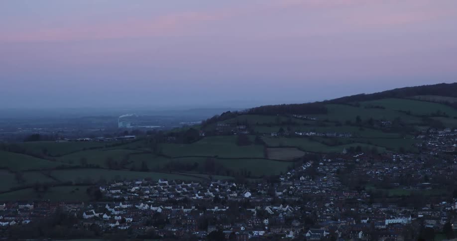 Landscape of an urban city built on hills against a purple sky