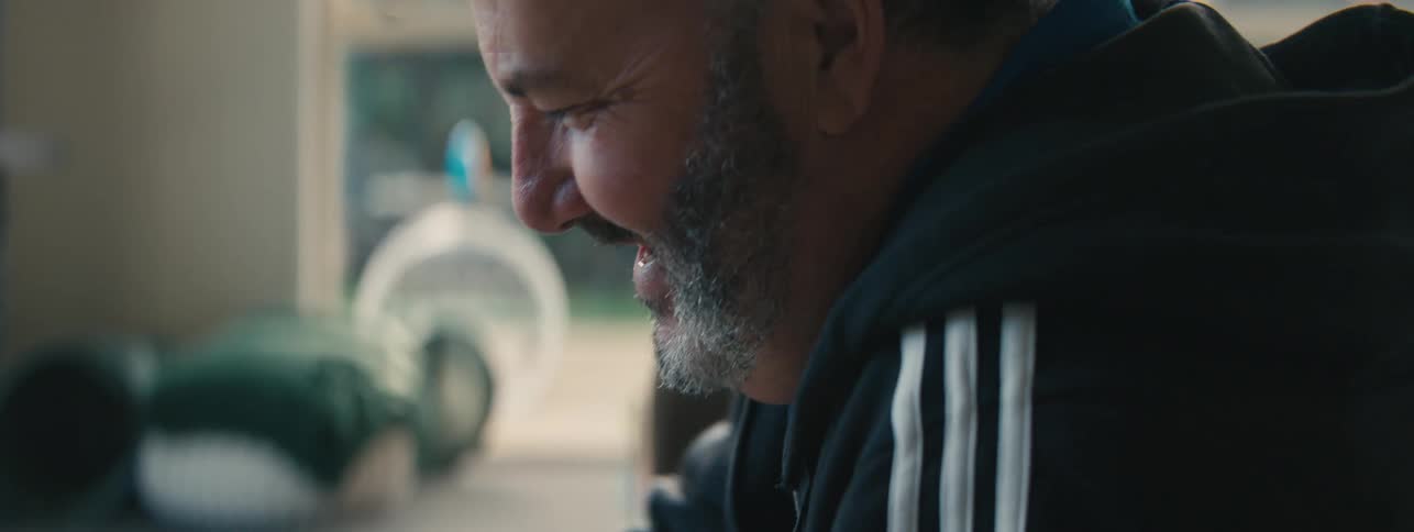 Side portrait of a bearded man with happy facial expression