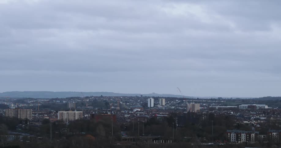 Panorama of a metropolis with a silhouette of mountains on the horizon on a cloudy day