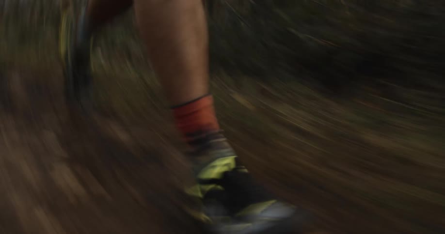 A woman runs down a dirt path in a forest