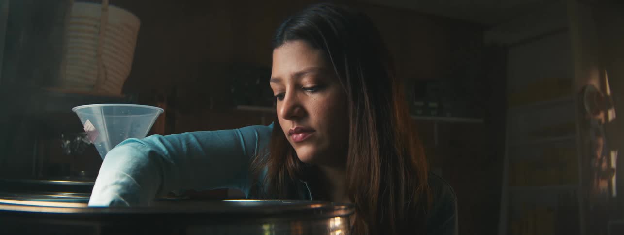 A woman mixes an ingredient into a container and mixes it