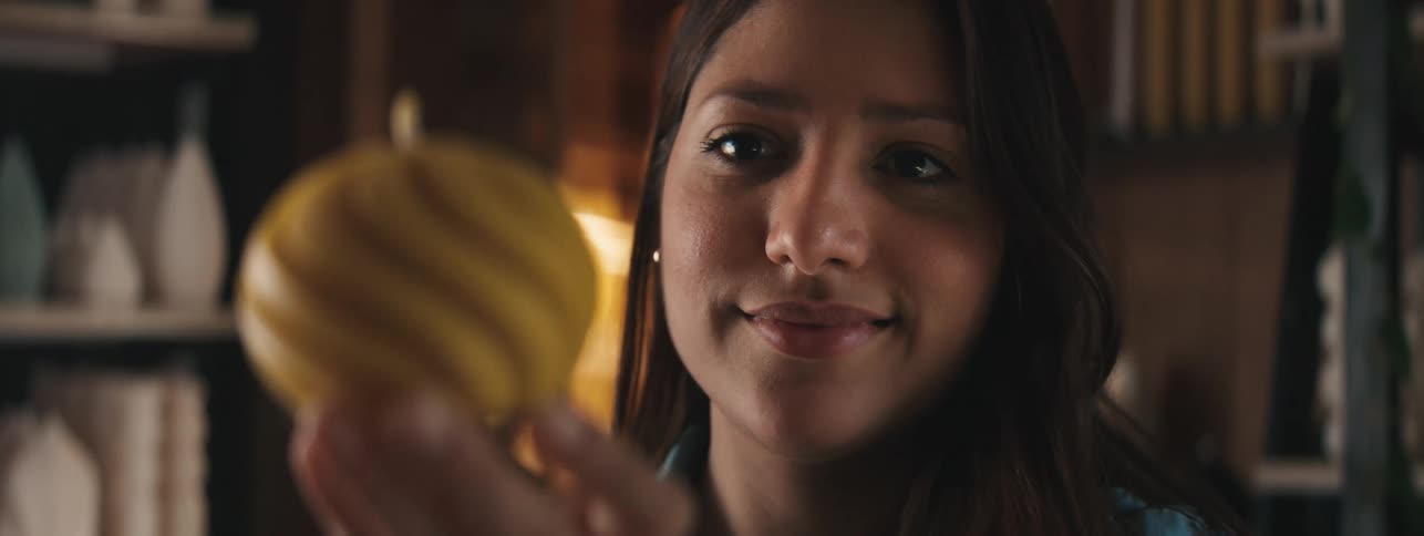 Portrait of a woman enjoying a yellow spherical candle