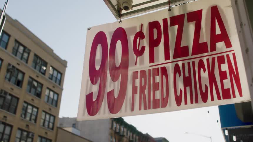 A hanging sign indicating a discount pizza and chicken shop