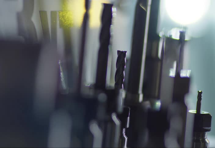 A swinging light casts shadows on screws