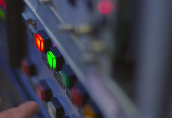 A man pushes a lighted green button on a machine