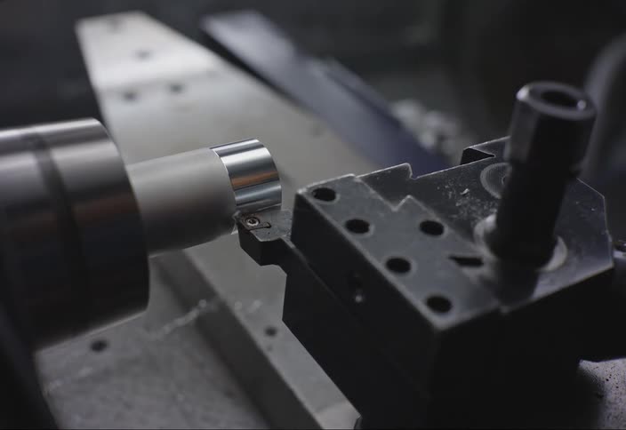 A machine is spinning and shaving metal off a rod
