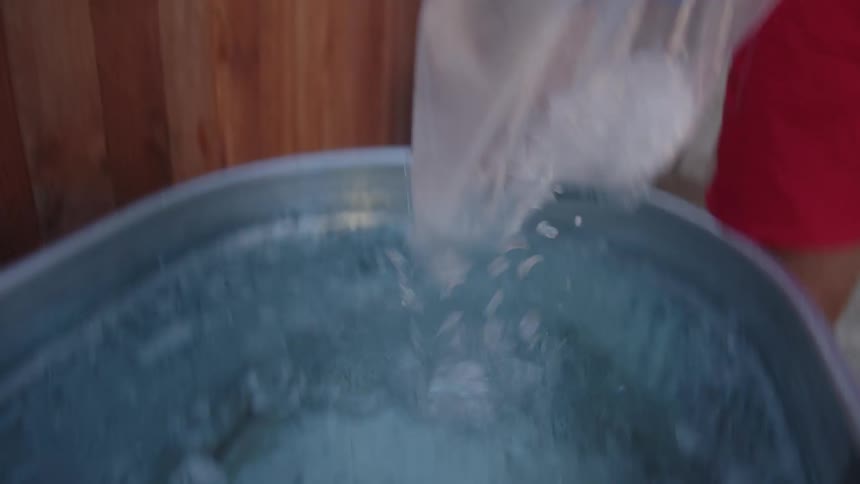 Man pouring ice into a bathtub