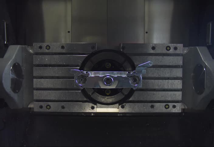 A machine spins as another device drops down to tighten screws