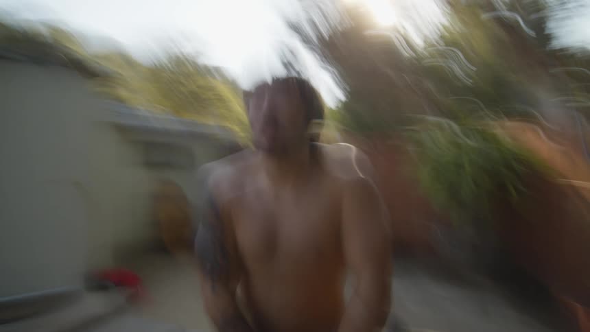 Man in an outdoor area surrounded by vegetation stretching his body