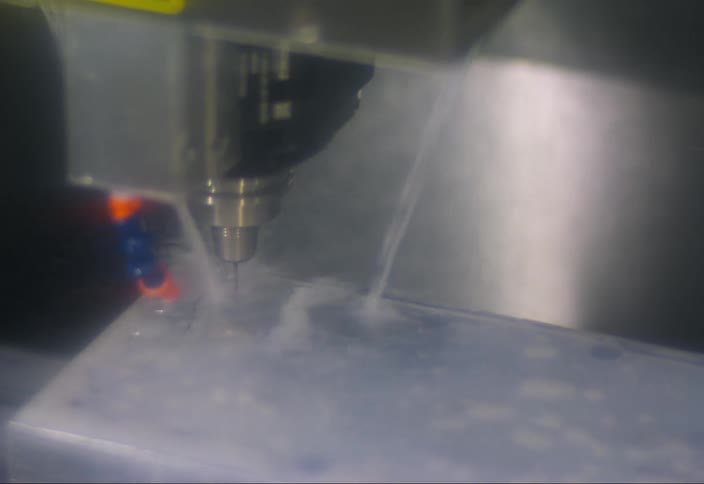 A machine rinses a metal plate with water