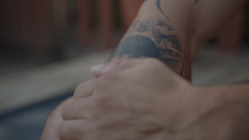 Hand massaging a tattooed arm