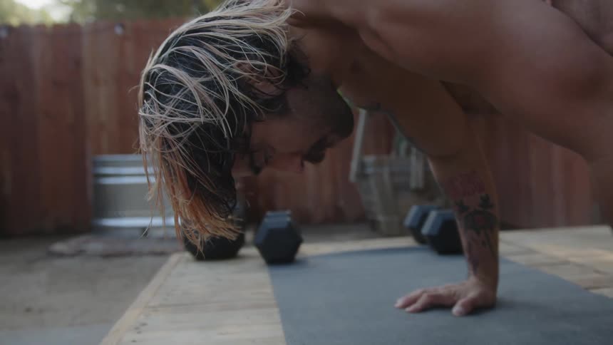 Man with hands on the ground and feet raised in an exercise position