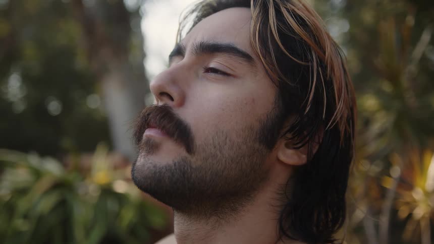 A man doing neck exercises then opening his eyes