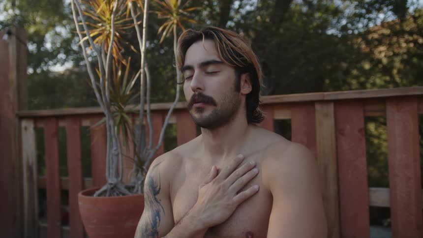 Man with hand on chest sitting meditating