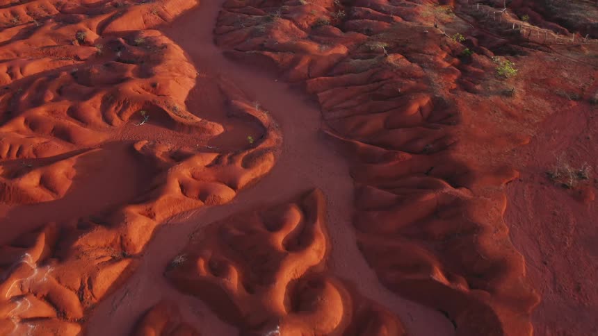 Aerial view of intricate patterns in red sand with sandstone and desert dunes