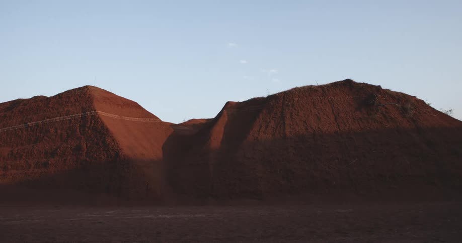 A couple hills of dirt half in shadow