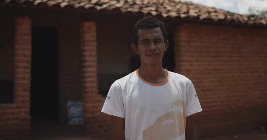 Man outside with brick house in background