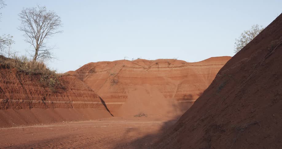 Arid mound of land with sparse vegetation
