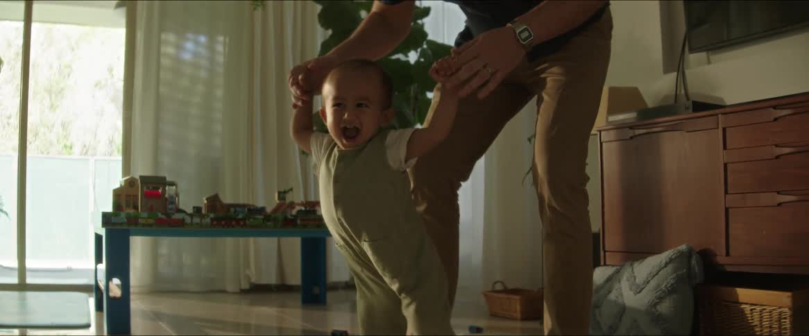 A father helps his baby walk
