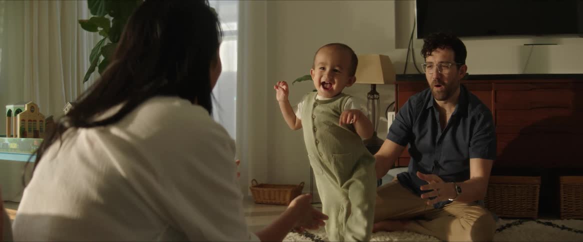 A clip of a father and mother teaching their son to walk