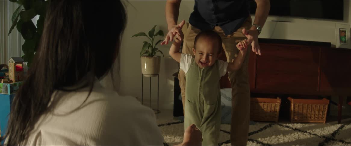 A father helps his baby take his first steps