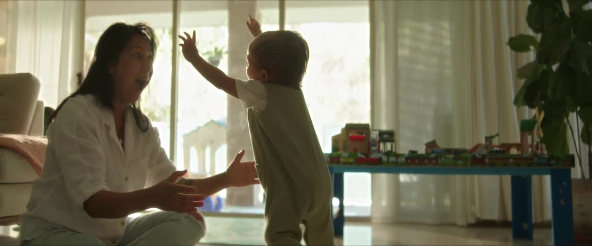 A clip of a mother and father playing with the kid