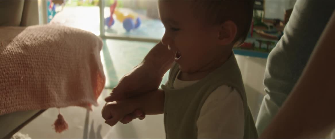Small child learning to walk with an adult helping