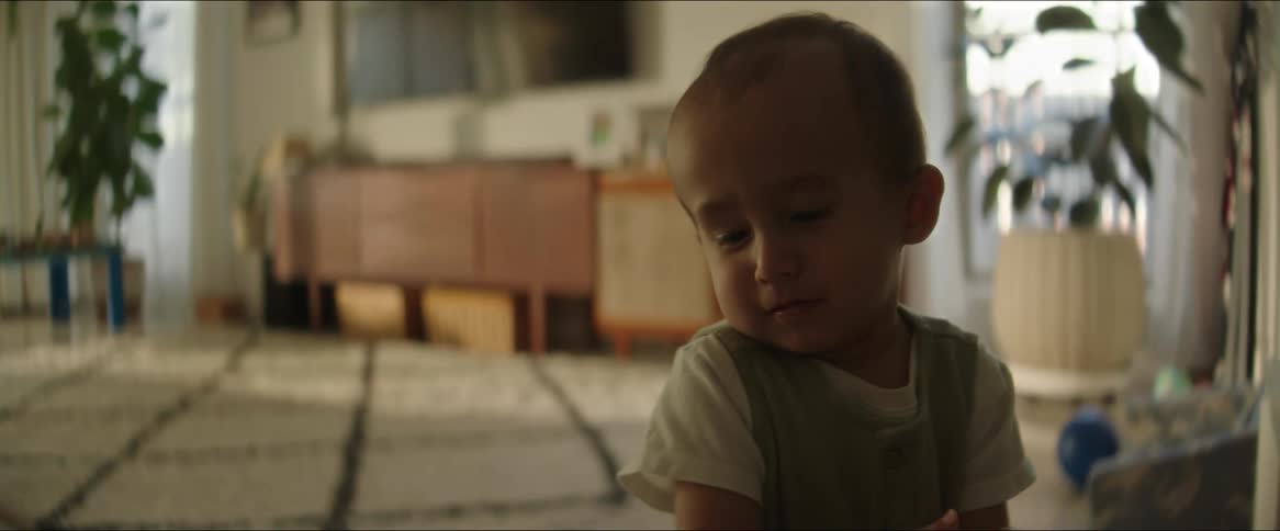 A child is sitting and moving his hands around