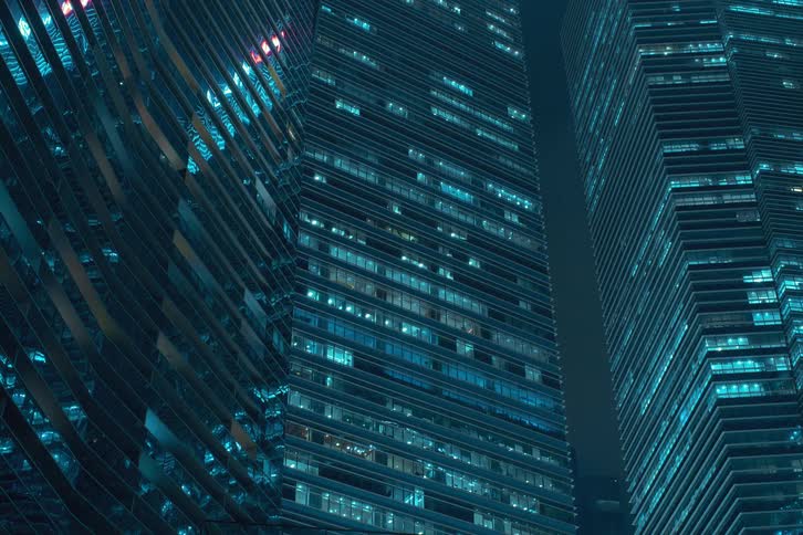 A night clip of highrise buildings in the city as all of its lights turn on together