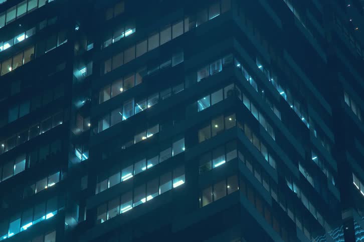 Window lights turn on at every floor of a tall office building