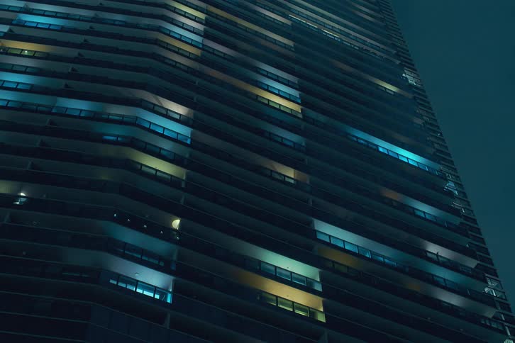 A speed up timelapse of office window lights turning on at night