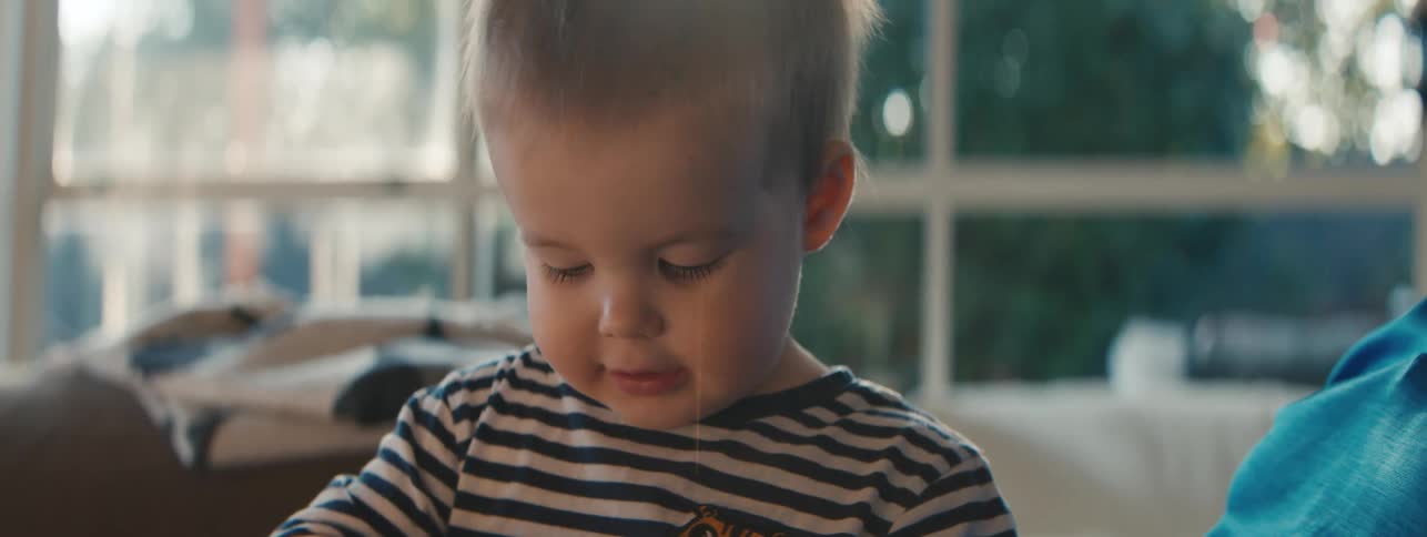 Little boy sitting on his fathers lap in the living room