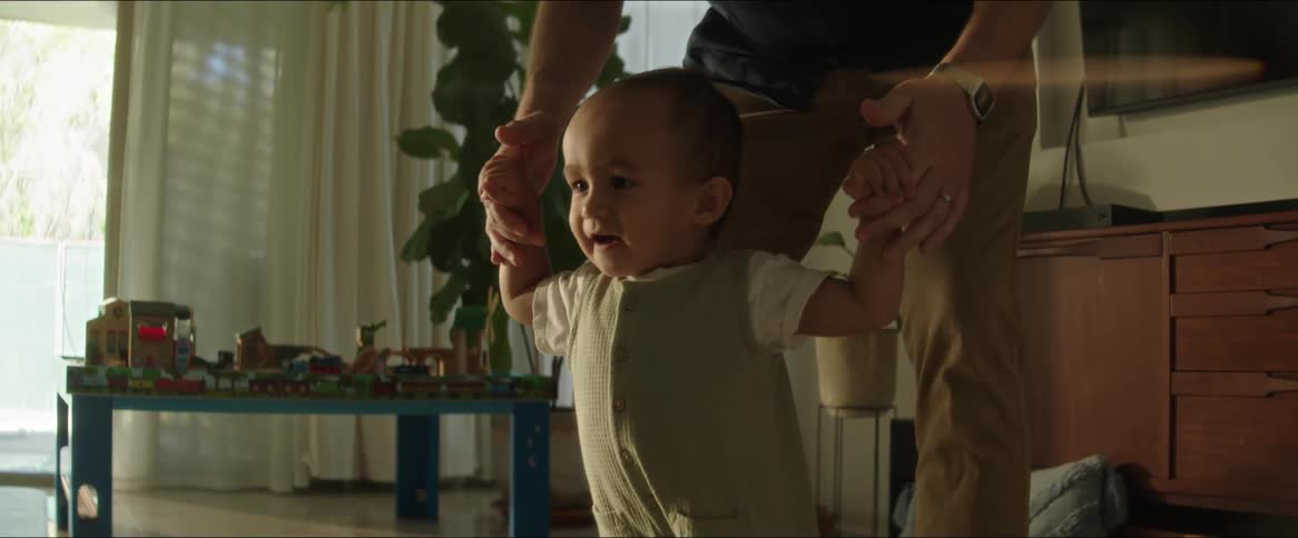 Happy child learning to walk with the help of an adult