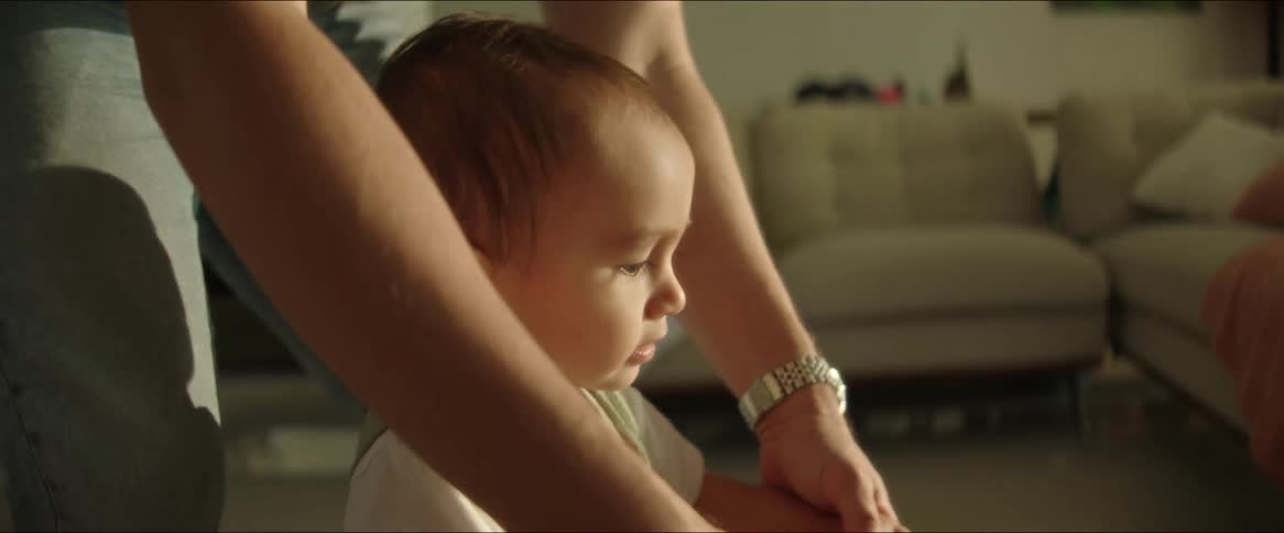 A clip of a father teaching and infant to walk